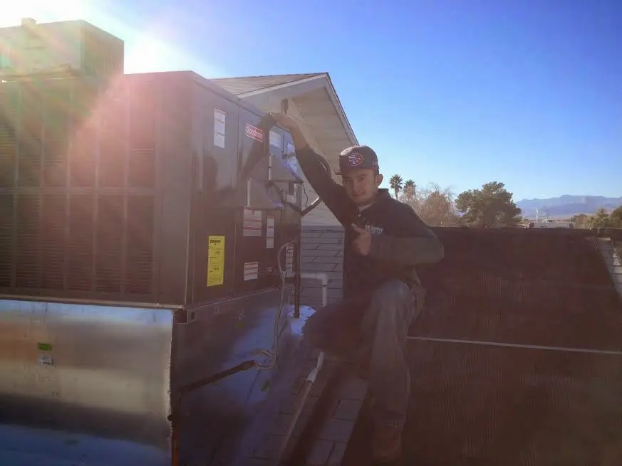 HVAC technician performing Air Duct Repair on a rooftop unit in College Park